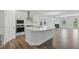 Modern kitchen with white cabinets, stainless steel appliances, and a large center island at 413 Edison Rail Ln, Knightdale, NC 27545