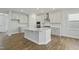 Bright kitchen with white cabinets, stainless steel appliances, and island at 413 Edison Rail Ln, Knightdale, NC 27545