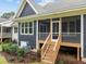 A covered back porch features wood steps with manicured landscaping at 416 S Cross St, Youngsville, NC 27596