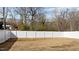 Large, empty backyard with a white vinyl fence and tree-lined perimeter at 416 S Cross St, Youngsville, NC 27596