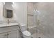 A bright bathroom featuring a glass shower with a bench, neutral tile, and updated gold hardware at 416 S Cross St, Youngsville, NC 27596
