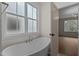 A bright bathroom featuring a freestanding tub beneath a window, offering a serene bathing experience at 416 S Cross St, Youngsville, NC 27596