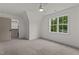 A neutral carpeted bedroom featuring views of a neighborhood through a centrally placed window at 416 S Cross St, Youngsville, NC 27596