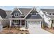 Charming home with navy siding, white trim, two-car garage, and landscaped front yard at 416 S Cross St, Youngsville, NC 27596