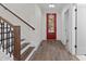Entryway with hardwood staircase and stylish red front door at 416 S Cross St, Youngsville, NC 27596