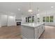 Open-concept living area with a kitchen island, fireplace, and large windows at 416 S Cross St, Youngsville, NC 27596