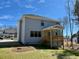 Back view of a gray two-story house with a wooden deck and a well-maintained lawn, great for outdoor living at 168 Grand Griffon Way, Lillington, NC 27546