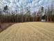 A spacious backyard with newly laid straw and a shed in the distance at 168 Grand Griffon Way, Lillington, NC 27546
