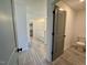 An open-concept bathroom features tile flooring, a tub, and an open door at 168 Grand Griffon Way, Lillington, NC 27546