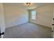 Carpeted bedroom with neutral walls, ample natural light from the large window, and neutral walls at 168 Grand Griffon Way, Lillington, NC 27546