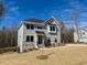 Two-story home with light gray siding, stone accents, black trim, and a newly seeded lawn at 168 Grand Griffon Way, Lillington, NC 27546