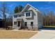 Two-story house with light gray siding, stone accents, a well-kept lawn, and an attached garage at 168 Grand Griffon Way, Lillington, NC 27546