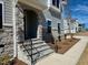 Elegant stone entryway with a covered porch, black iron railing, and newly planted landscaping at 168 Grand Griffon Way, Lillington, NC 27546