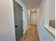 Second floor hallway with light hardwood floors, neutral walls and a gray interior door at 168 Grand Griffon Way, Lillington, NC 27546