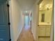 Hallway featuring hardwood floors leads to a bright bathroom and other rooms at 168 Grand Griffon Way, Lillington, NC 27546