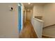 Upstairs hallway with wooden floors, white walls, and white trim with multiple doors and hall lighting at 168 Grand Griffon Way, Lillington, NC 27546