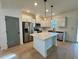 This bright kitchen is designed with stainless steel appliances, an island, and white cabinets at 168 Grand Griffon Way, Lillington, NC 27546