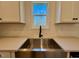 Farmhouse sink in a kitchen with quartz countertops, a bright window, and white cabinets at 168 Grand Griffon Way, Lillington, NC 27546