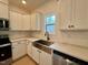 Kitchen with stainless farmhouse sink, white subway tile backsplash, and bright window at 168 Grand Griffon Way, Lillington, NC 27546