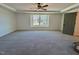 Spacious main bedroom with a ceiling fan, a large window and neutral-toned carpet flooring at 168 Grand Griffon Way, Lillington, NC 27546