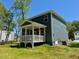 Side view of house with a large backyard and covered porch at 196 Grand Griffon Way, Lillington, NC 27546