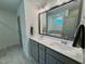 Modern bathroom with a large framed mirror, dual sinks, and grey cabinets at 196 Grand Griffon Way, Lillington, NC 27546
