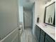 Bright bathroom with double sink vanity, grey cabinets, tile floor, and step-in shower at 196 Grand Griffon Way, Lillington, NC 27546