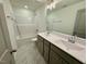 Bathroom featuring tiled flooring, a dual sink vanity, a large mirror, and a shower over tub at 196 Grand Griffon Way, Lillington, NC 27546
