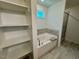 Bathroom featuring a soaking tub with tile surround, shelving, and a shower at 196 Grand Griffon Way, Lillington, NC 27546