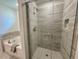 Bathroom features a glass enclosed shower with gray tile, as well as a soaking tub at 196 Grand Griffon Way, Lillington, NC 27546