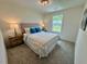 Cozy bedroom featuring a comfortable bed, soft carpet, and natural light from a nearby window at 196 Grand Griffon Way, Lillington, NC 27546