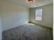 Cozy bedroom featuring neutral carpeting, natural light, and a view of the outdoors at 196 Grand Griffon Way, Lillington, NC 27546