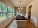 Dining room features hardwood floors, a modern chandelier, and large windows overlooking greenery at 196 Grand Griffon Way, Lillington, NC 27546