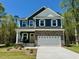 Charming two-story home with stone accents, a two-car garage, and a bright yellow front door at 196 Grand Griffon Way, Lillington, NC 27546
