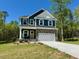 Charming two-story home featuring stone accents, a two-car garage, and a neatly landscaped front yard at 196 Grand Griffon Way, Lillington, NC 27546