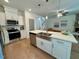 Well-lit kitchen with stainless steel appliances, white cabinets, and a large island featuring a stainless steel sink at 196 Grand Griffon Way, Lillington, NC 27546