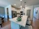 Modern kitchen with white cabinetry, stainless steel appliances, an island with seating, and stylish pendant lighting at 196 Grand Griffon Way, Lillington, NC 27546