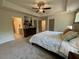 Main bedroom features neutral walls, carpet, and tray ceiling with adjacent bathroom at 196 Grand Griffon Way, Lillington, NC 27546