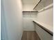 Bright walk-in closet featuring carpet flooring, white walls and wood shelving with metal supports at 196 Grand Griffon Way, Lillington, NC 27546