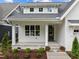 Inviting front porch with classic columns, stone accents, and professionally landscaped garden at 414 S Cross St, Youngsville, NC 27596