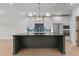 Spacious kitchen with a large dark island, modern appliances and custom backsplash at 414 S Cross St, Youngsville, NC 27596