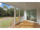 Relax on this screened-in porch with wood flooring, white railing and views of the lawn and trees at 414 S Cross St, Youngsville, NC 27596
