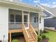 Back view of home featuring a screened in porch with wooden stairs leading to the back yard at 414 S Cross St, Youngsville, NC 27596
