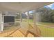 Enjoy outdoor living on this screened porch with wooden floors and views of the backyard and pond at 414 S Cross St, Youngsville, NC 27596