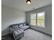 Cozy room with a comfortable couch and view of trees outside a large window at 152 S Mistflower St, Clayton, NC 27520