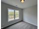 Sunlit bedroom featuring a view of trees outside a large window and neutral carpet at 152 S Mistflower St, Clayton, NC 27520