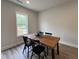 Cozy dining area with a wooden table, black chairs, and natural light from the window at 152 S Mistflower St, Clayton, NC 27520