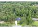 Stunning aerial view of a brick home featuring a private pool surrounded by lush greenery, providing serene retreat at 184 Pine E St, Lillington, NC 27546