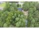 An aerial view shows a home nestled in a private, wooded lot with a long driveway at 184 Pine E St, Lillington, NC 27546