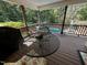 Relaxing back porch with seating, view to the pool, and natural landscaping at 184 Pine E St, Lillington, NC 27546
